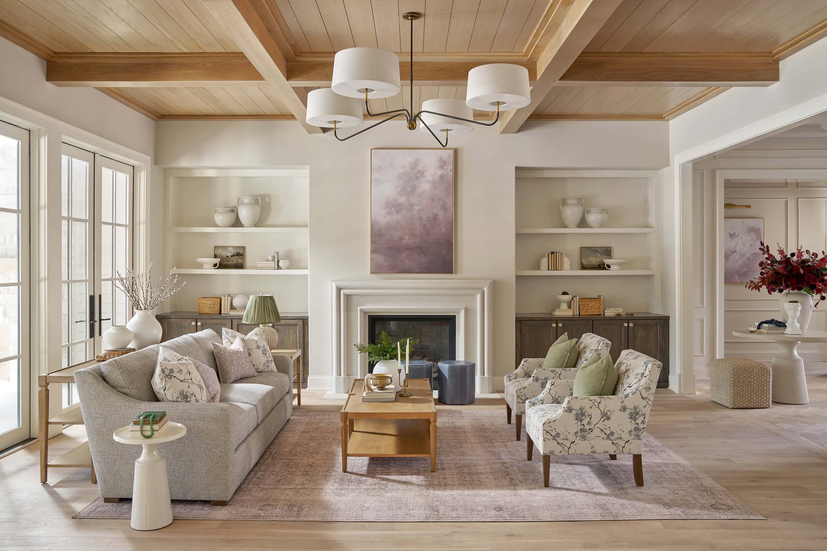 Cozy living room with comfortable sofas, armchairs, and a fireplace, featuring bright natural light.