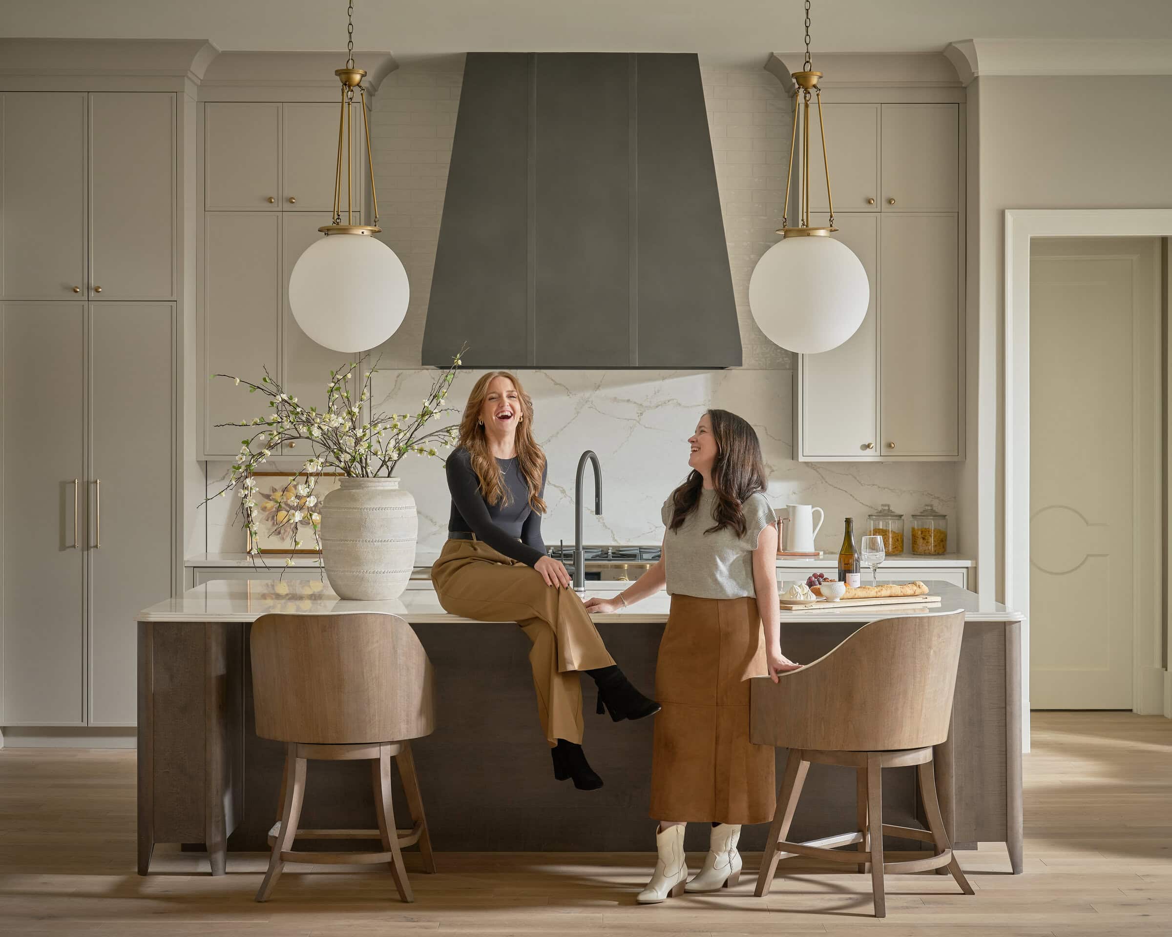 Stylish modern kitchen with two women chatting at the island.