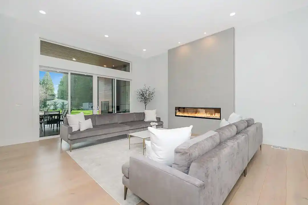 Spacious modern living room with fireplace and large windows, bright and inviting.