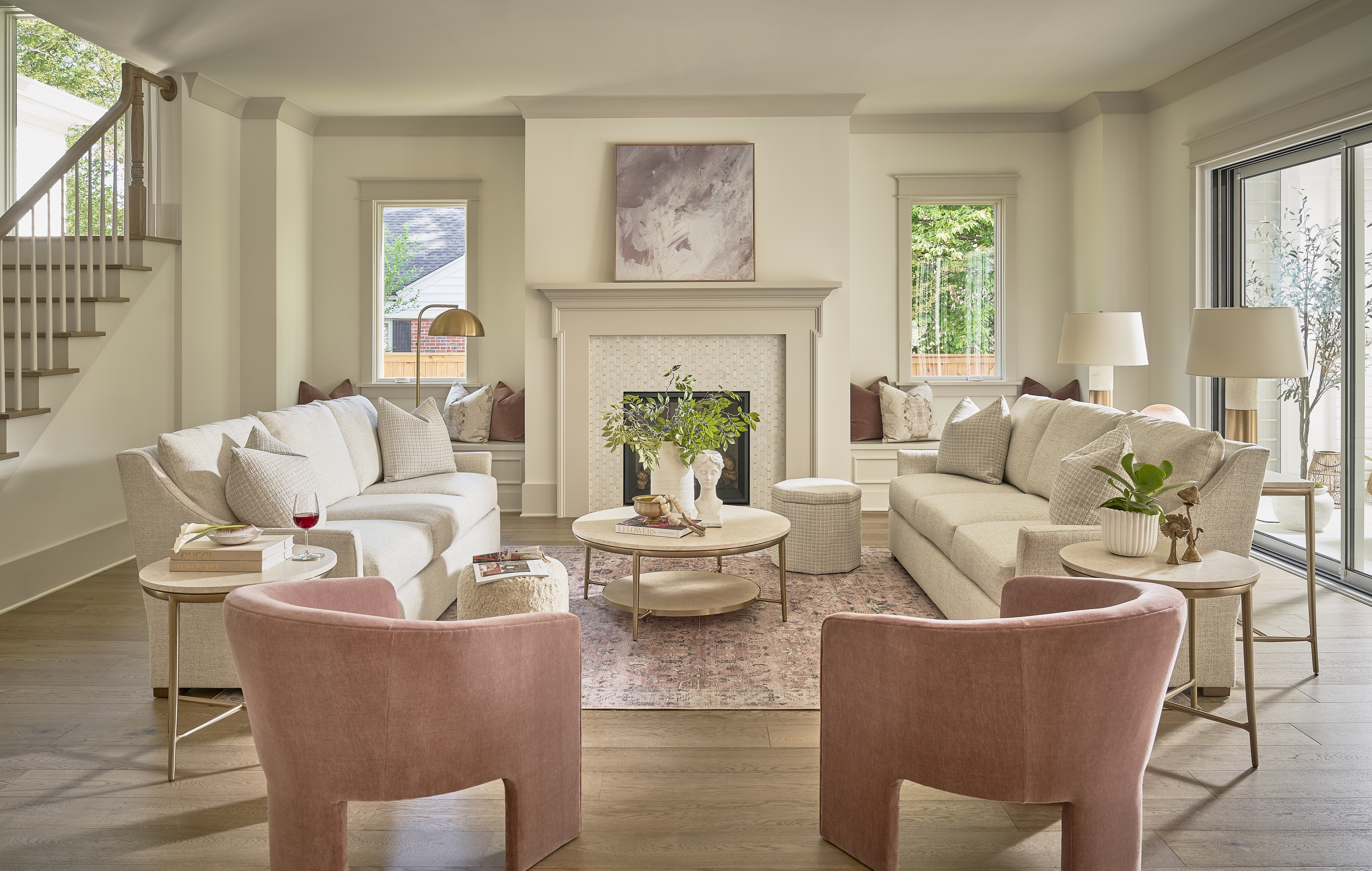 Spacious living room with neutral tones, large windows, and cozy seating.